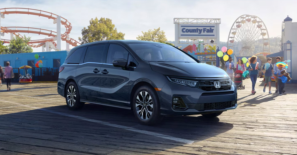 A Honda Odyssey parked in front of a county fair
