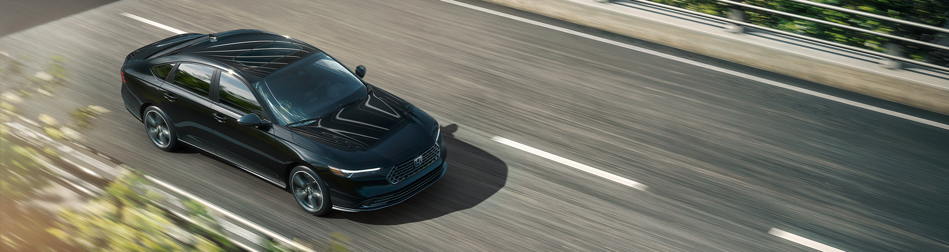 A Honda Accord midsize sedan in black driving along a multi-lane highway from an elevated overhead perspective.